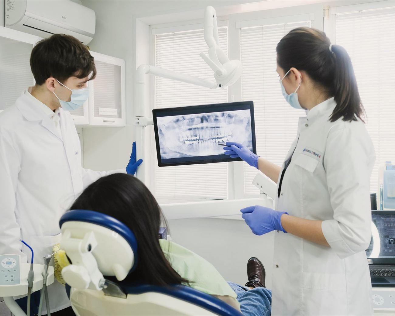 Dos especialistas revisan con la paciente su radiografía en pantalla